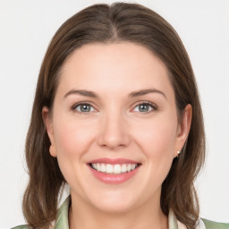 Joyful white young-adult female with medium  brown hair and grey eyes