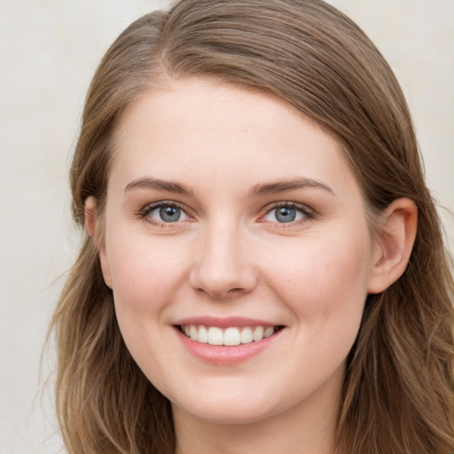 Joyful white young-adult female with long  brown hair and blue eyes