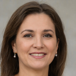 Joyful white adult female with long  brown hair and grey eyes