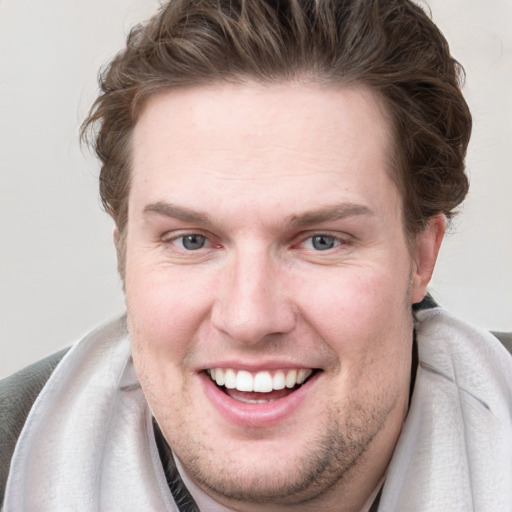 Joyful white young-adult male with short  brown hair and blue eyes