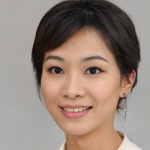 Joyful asian young-adult female with medium  brown hair and brown eyes