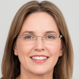 Joyful white adult female with long  brown hair and green eyes