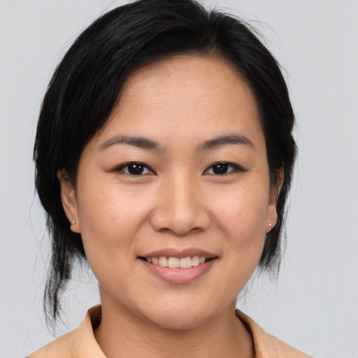 Joyful asian young-adult female with medium  brown hair and brown eyes