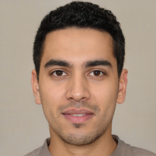Joyful latino young-adult male with short  black hair and brown eyes