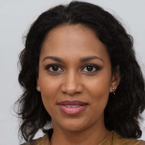 Joyful black young-adult female with long  brown hair and brown eyes