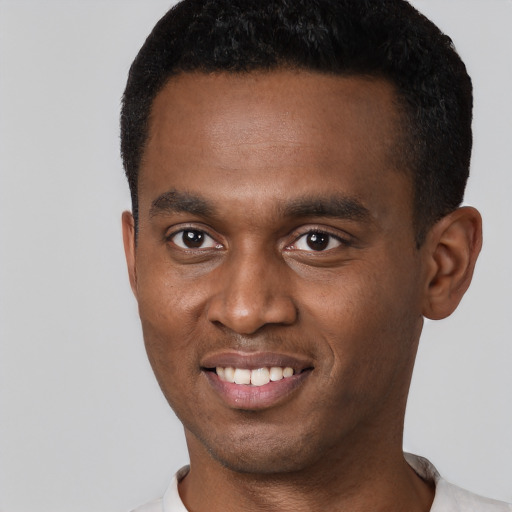 Joyful black young-adult male with short  black hair and brown eyes