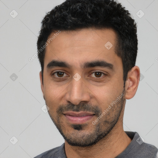Joyful latino young-adult male with short  black hair and brown eyes
