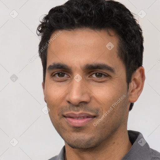 Joyful latino young-adult male with short  black hair and brown eyes