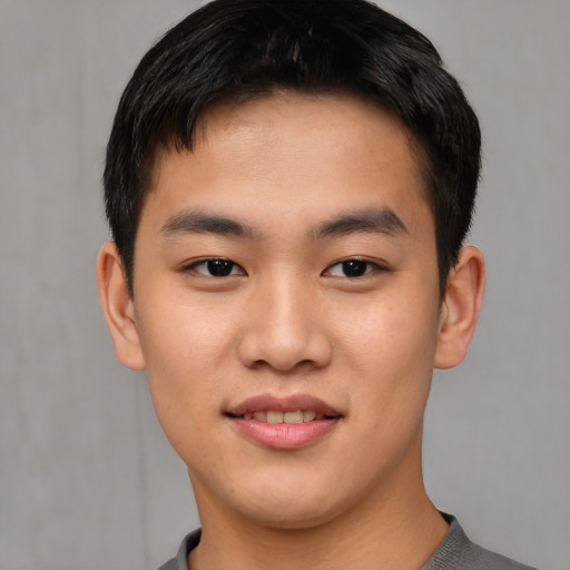 Joyful asian young-adult male with short  brown hair and brown eyes