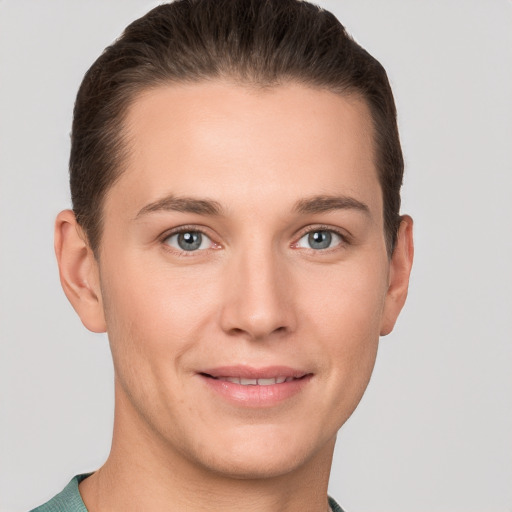 Joyful white young-adult male with short  brown hair and grey eyes