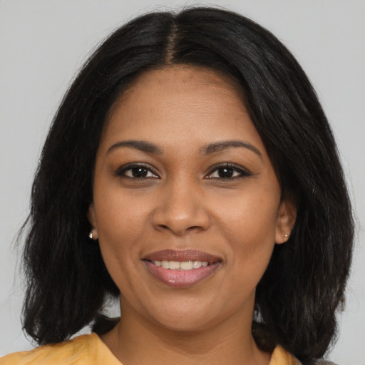Joyful black young-adult female with long  black hair and brown eyes