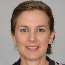 Joyful white adult female with medium  brown hair and grey eyes