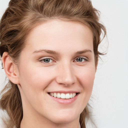 Joyful white young-adult female with long  brown hair and blue eyes