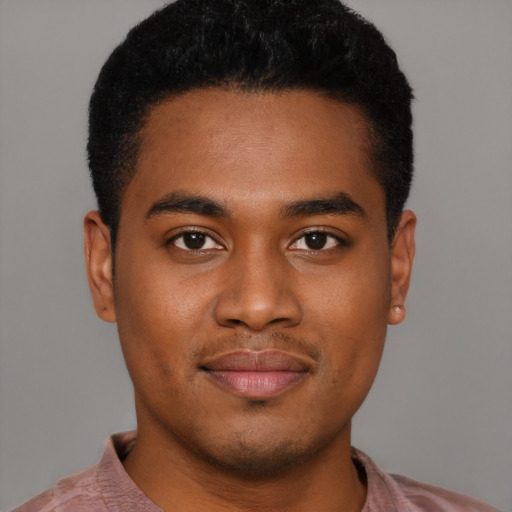 Joyful black young-adult male with short  brown hair and brown eyes