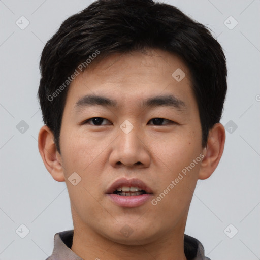 Joyful asian young-adult male with short  black hair and brown eyes