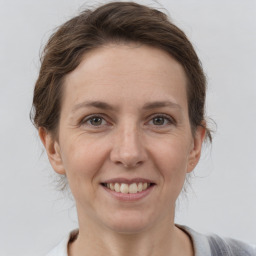 Joyful white adult female with medium  brown hair and grey eyes