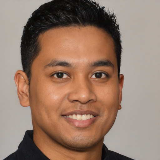Joyful latino young-adult male with short  brown hair and brown eyes