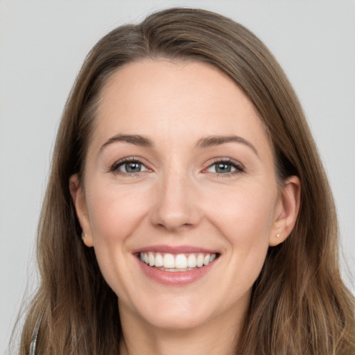 Joyful white young-adult female with long  brown hair and grey eyes