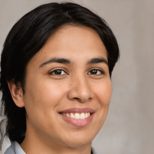 Joyful latino young-adult female with medium  brown hair and brown eyes