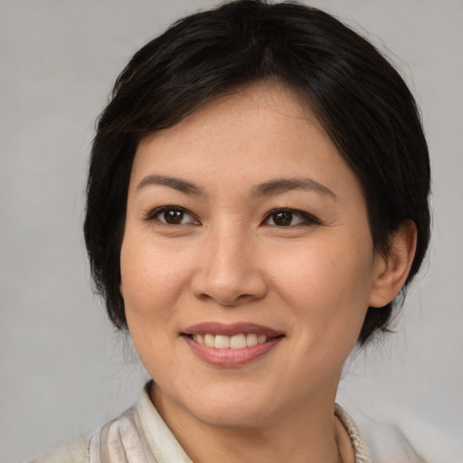 Joyful asian young-adult female with medium  brown hair and brown eyes