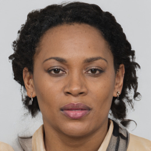 Joyful black adult female with medium  brown hair and brown eyes