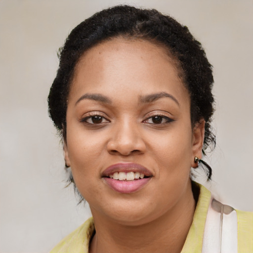 Joyful black young-adult female with short  black hair and brown eyes