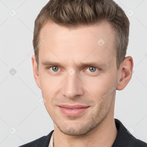 Joyful white young-adult male with short  brown hair and grey eyes