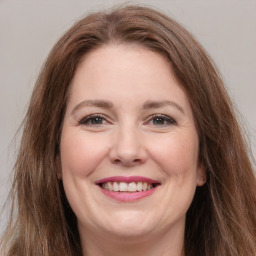 Joyful white adult female with long  brown hair and grey eyes