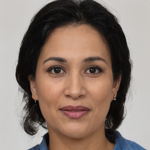 Joyful latino adult female with medium  brown hair and brown eyes