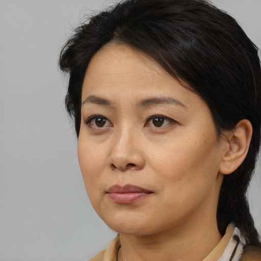 Joyful asian adult female with medium  brown hair and brown eyes