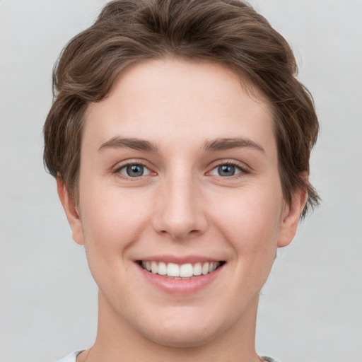 Joyful white young-adult female with short  brown hair and grey eyes