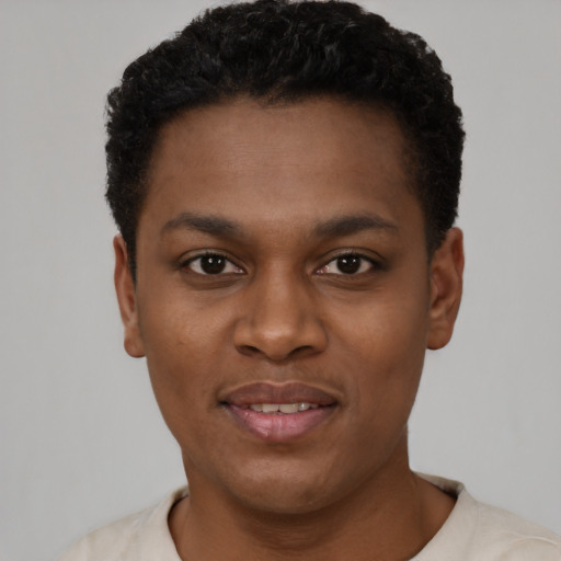 Joyful black young-adult male with short  black hair and brown eyes