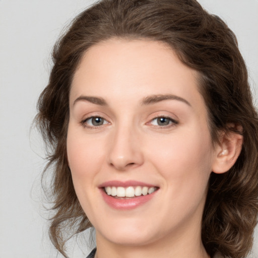 Joyful white young-adult female with medium  brown hair and green eyes