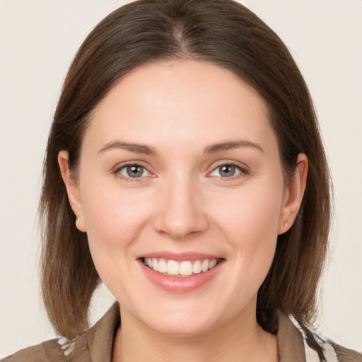 Joyful white young-adult female with medium  brown hair and grey eyes