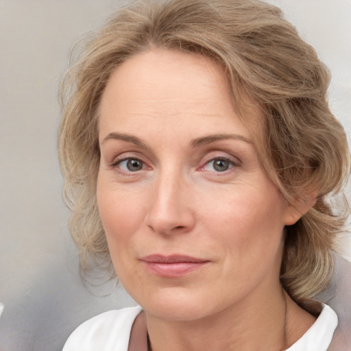 Joyful white adult female with medium  brown hair and blue eyes