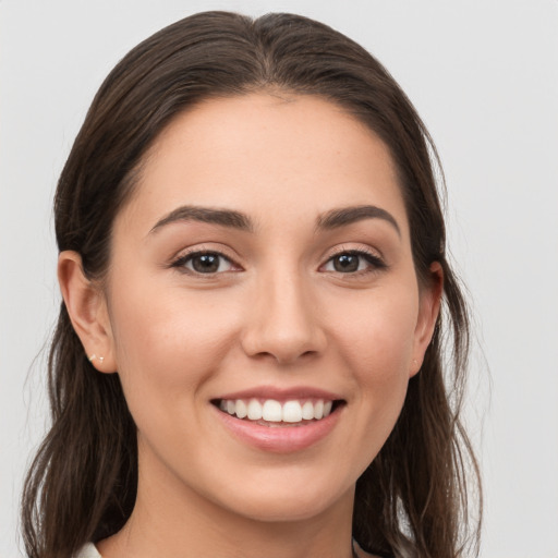 Joyful white young-adult female with medium  brown hair and grey eyes