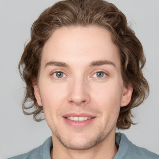 Joyful white young-adult male with medium  brown hair and blue eyes