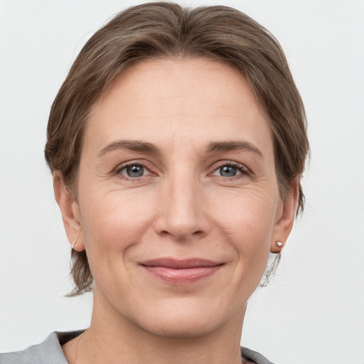 Joyful white adult female with medium  brown hair and grey eyes