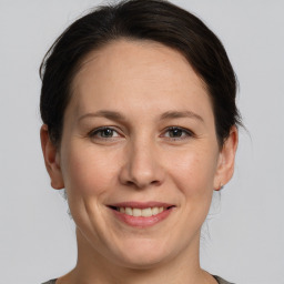 Joyful white adult female with medium  brown hair and grey eyes