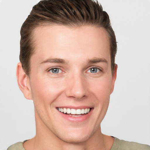 Joyful white young-adult male with short  brown hair and grey eyes