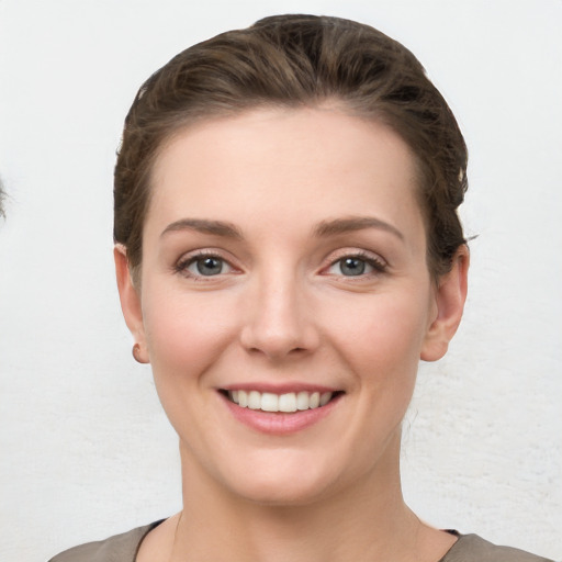 Joyful white young-adult female with short  brown hair and grey eyes