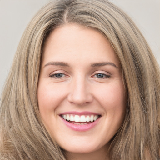 Joyful white young-adult female with long  brown hair and green eyes