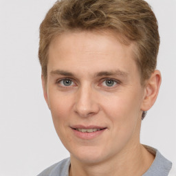 Joyful white young-adult male with short  brown hair and grey eyes