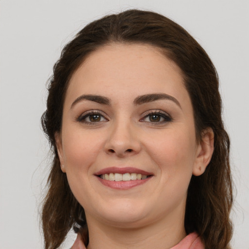 Joyful white young-adult female with long  brown hair and brown eyes