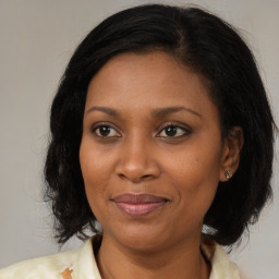 Joyful black adult female with medium  brown hair and brown eyes