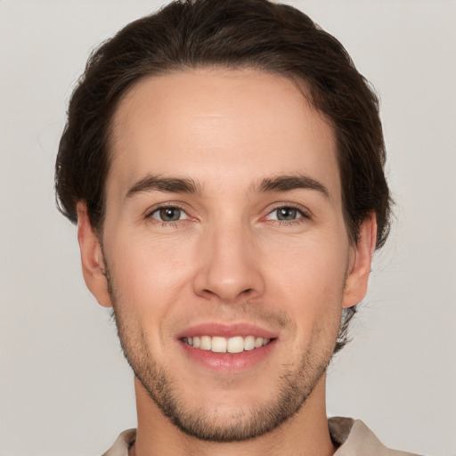 Joyful white young-adult male with short  brown hair and brown eyes