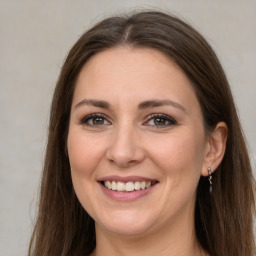 Joyful white adult female with long  brown hair and grey eyes