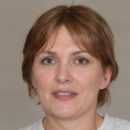 Joyful white adult female with medium  brown hair and blue eyes