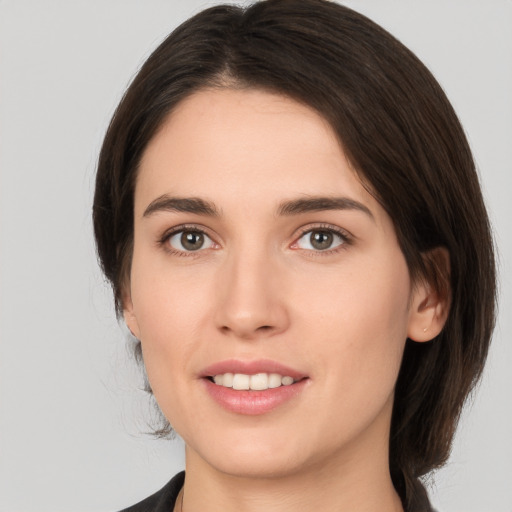 Joyful white young-adult female with medium  brown hair and brown eyes