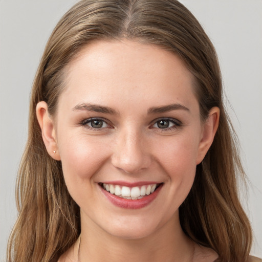 Joyful white young-adult female with long  brown hair and grey eyes